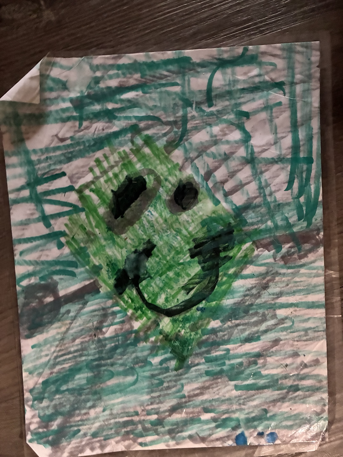 Rocco’s original green diamond smiley face on paper covered with green and gray marker strokes